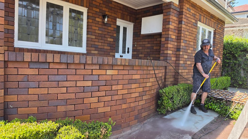 Pressure cleaning in progress beside a red-brick Sydney home